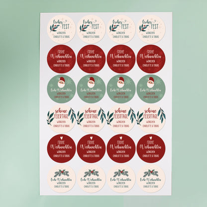 Bogen mit 24 runden Weihnachtsaufklebern in Rot, Grün und Beige, personalisierbar mit Text, vor mintgrünem Hintergrund fotografiert.