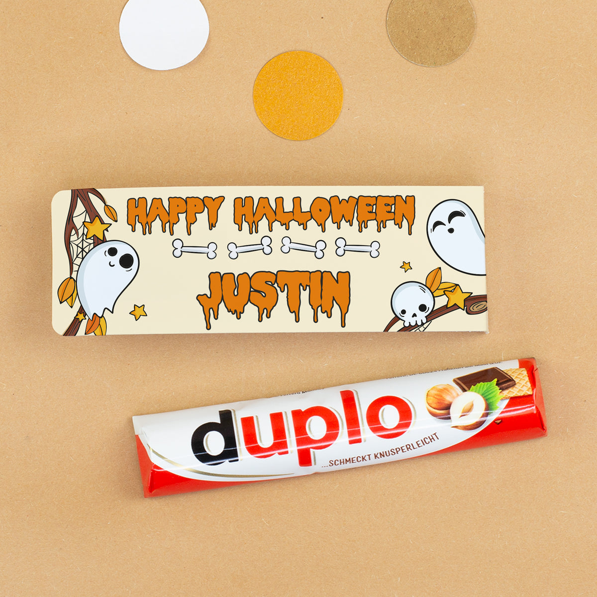 Duplo Riegel neben personalisierter Halloween-Geschenkverpackung mit Namen Justin, Geistern, Knochen und Totenkopf-Motiv