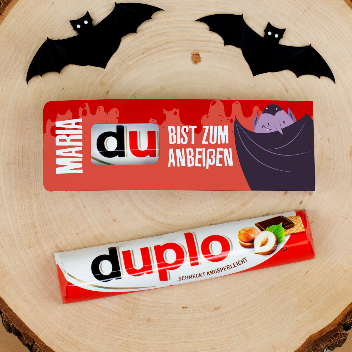 Duplo Riegel mit personalisierter Halloween-Verpackung Maria auf Holzscheibe mit schwarzen Fledermäusen