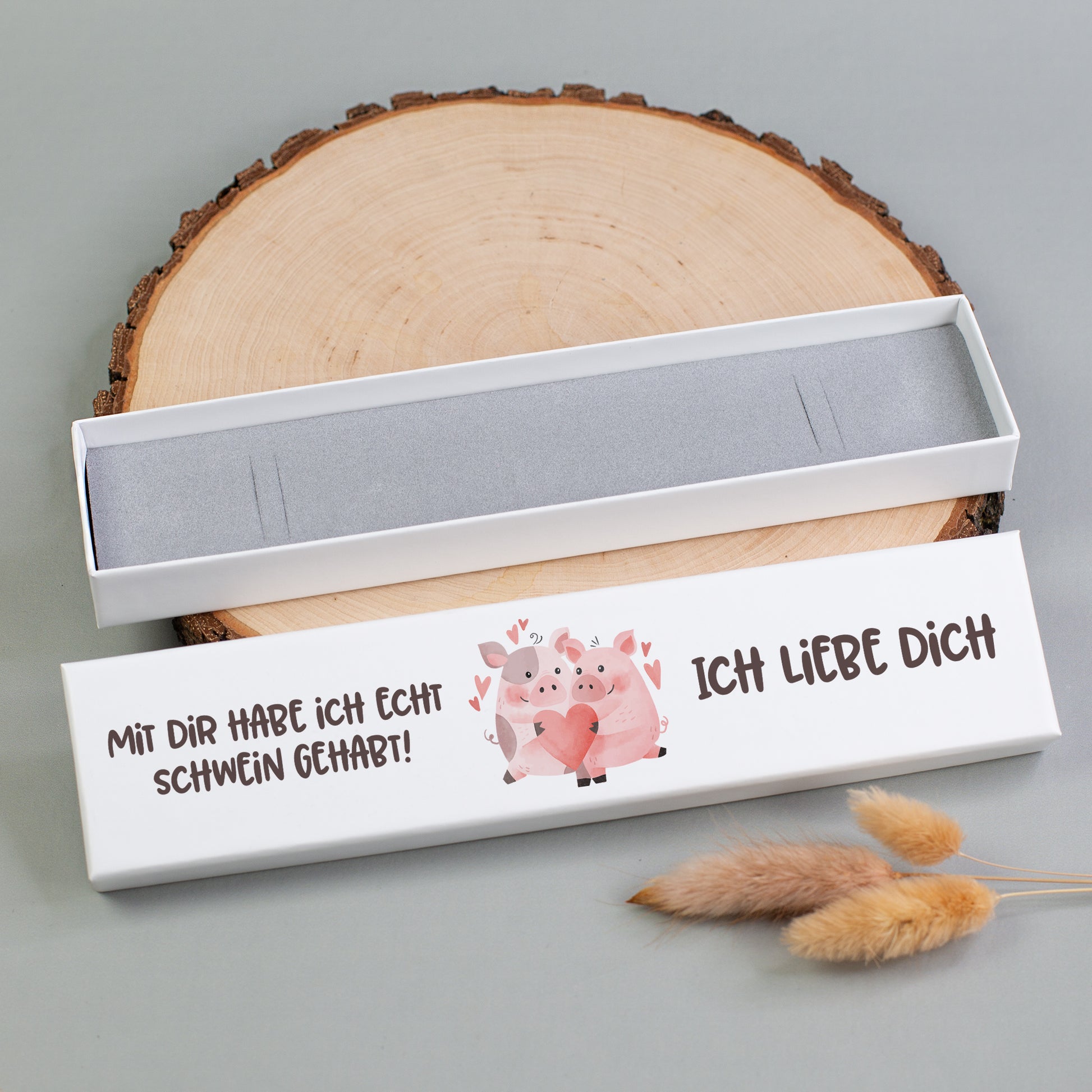Weiße Schmuckbox mit grauer Schaumstoffeinlage geöffnet, Deckel mit Schweinchen-Pärchen und personalisiertem Namen