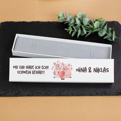 Schmuckverpackung mit Schweinchen-Motiv und Namen auf schwarzer Schieferplatte als Geschenkbox für Schmuck
