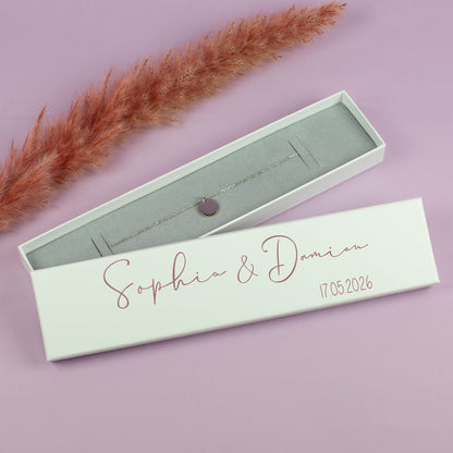 Schmuckschachtel Sophia & Damian in Rosa, mit Armband auf lila Untergrund