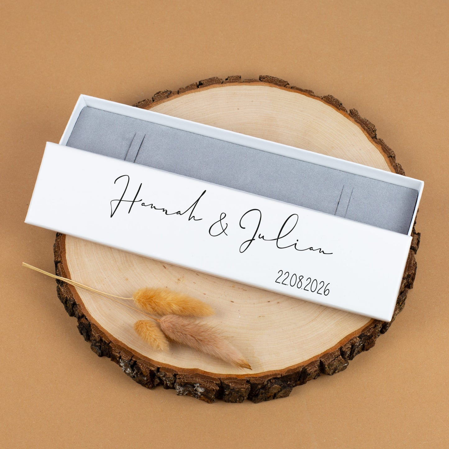 Schmuckverpackung Hannah & Julian in Schwarz, geöffnet auf Holzscheibe