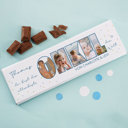 XXL-Schokolade mit Fotos und Wunschtext, dekorativ fotografiert auf blauem Hintergrund