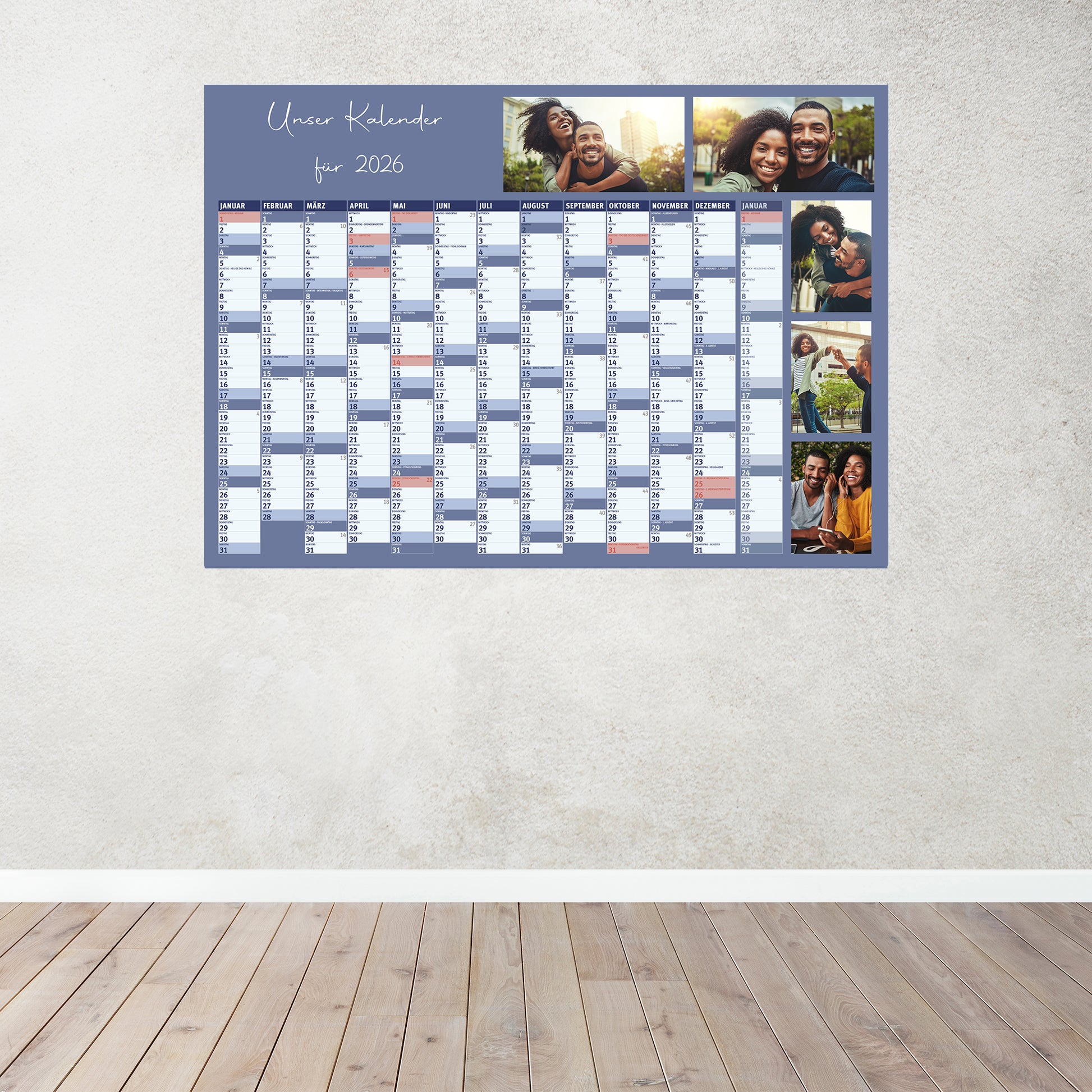 Blauer Fotokalender 2026 an einer hellen Wand, mit persönlichem Titel und Fotos, zeigt alle Monate im Überblick.