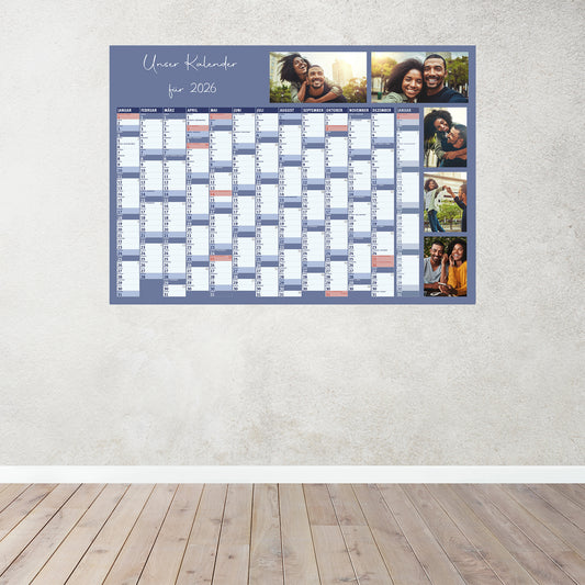 Blauer Fotokalender 2026 an einer hellen Wand, mit persönlichem Titel und Fotos, zeigt alle Monate im Überblick.