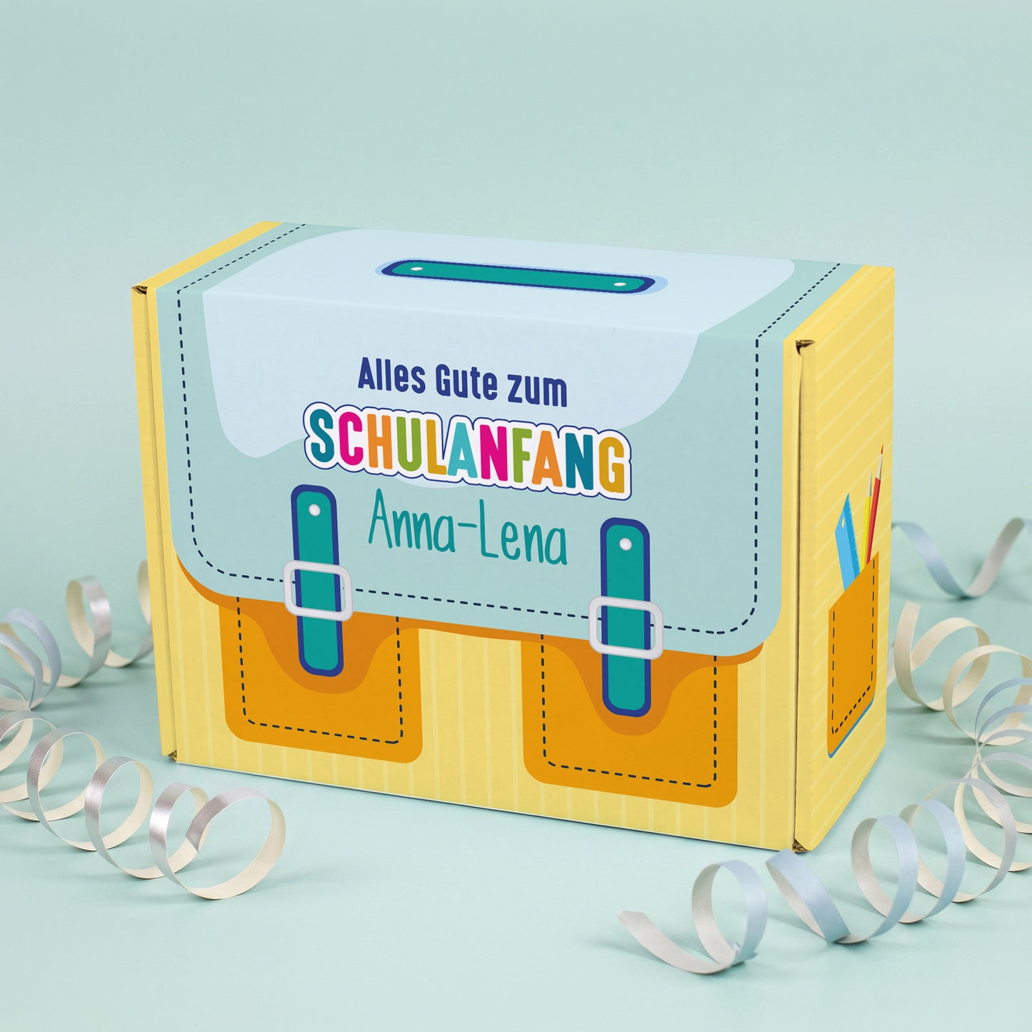 Kleine gelbe Geschenkverpackung zur Einschulung im Schulranzen-Design mit Name