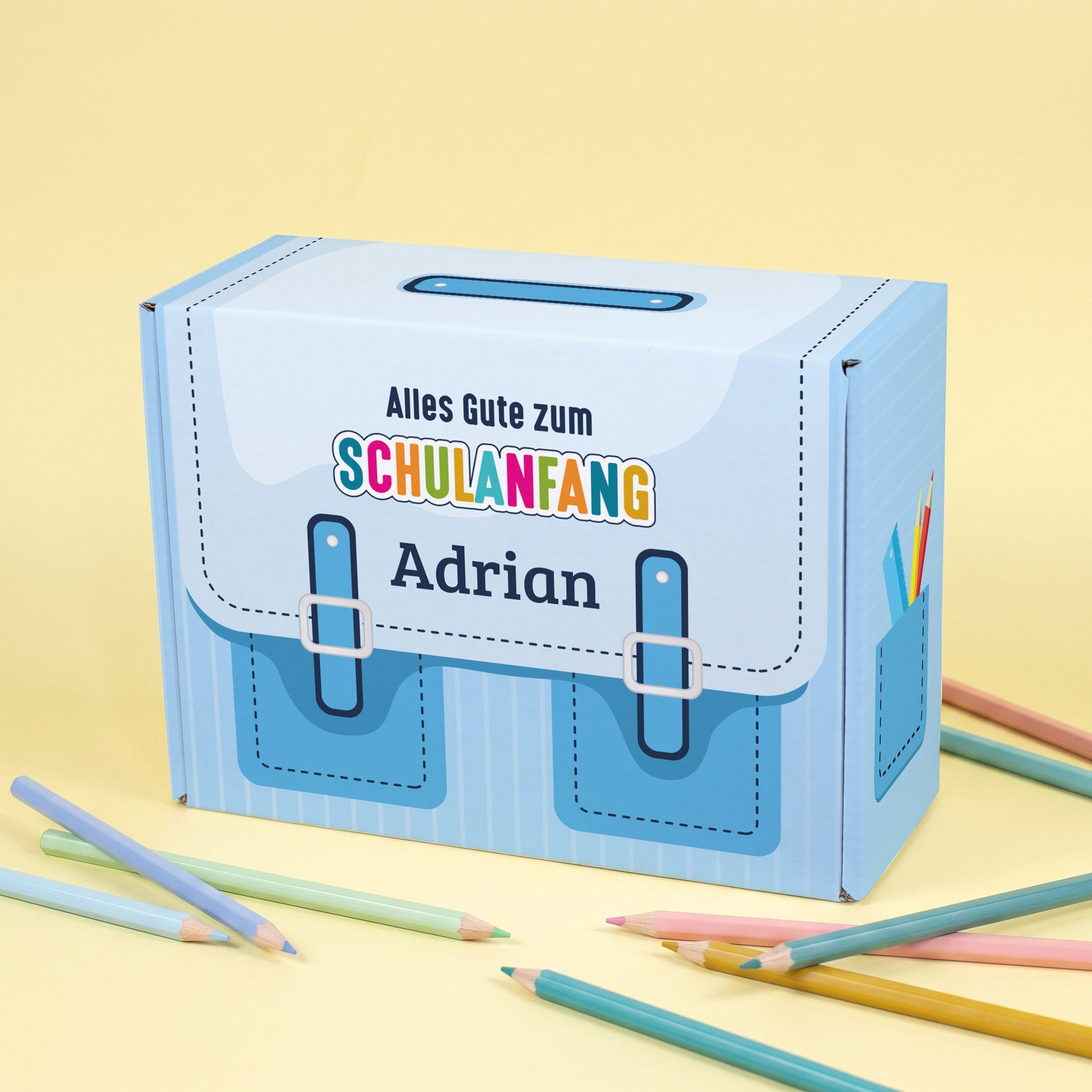 Kleine blaue Geschenkbox zur Einschulung im Schulranzen-Design mit Wunschname