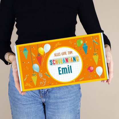 Mittlere personalisierte Geschenkbox mit Wunschname und buntem Schultüten-Motiv, von einer Person präsentiert