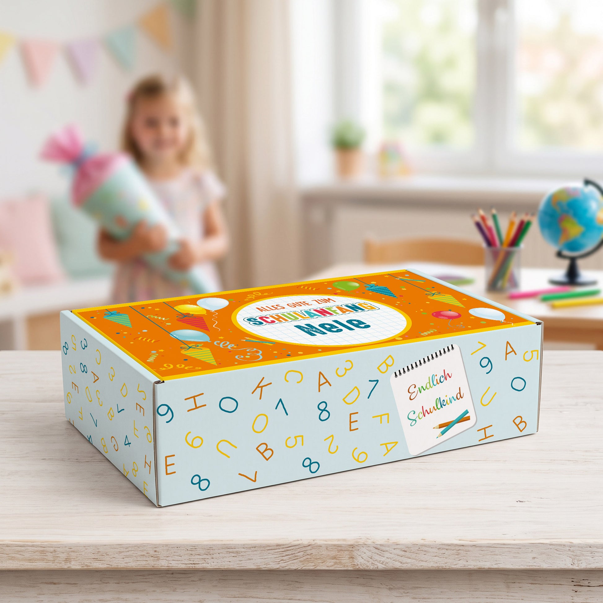 Mittlere Geschenkbox mit Name, bunten Schultüten und Luftballons vor einem Schulkind
