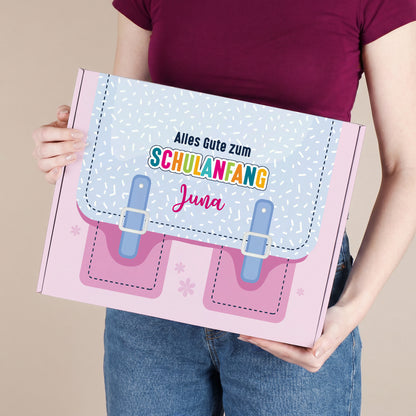 Große rosa Geschenkbox zum Schulanfang mit Name, von einer Person gehalten