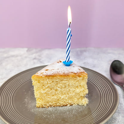 Stück Vanille Rührkuchen mit Geburtstagskerze auf Teller als Serviervorschlag