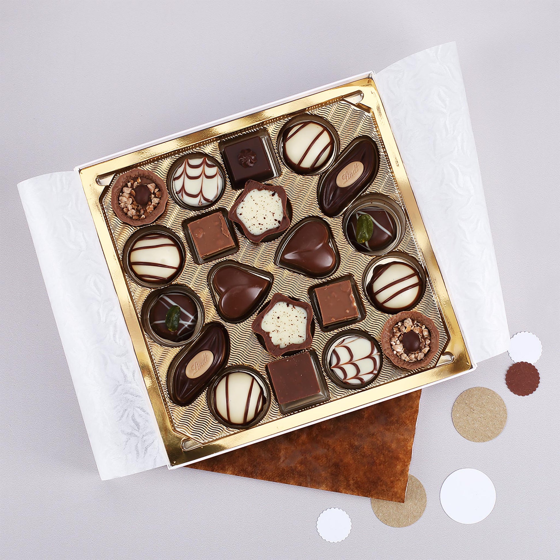 Offene Lindt Pralinenbox mit goldener Einlage und gemischten Mini-Pralinés als hochwertige Schokoladen-Geschenkidee