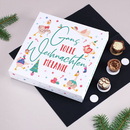Personalisierte Lindt Pralinenbox mit Spruch „Gans tolle Weihnachten Melanie“, festlich dekoriert mit Gänsemotiven und Tannenzweigen auf hellem Hintergrund.