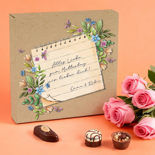 Lindt Pralinen Muttertag Geschenk mit Blumenmotiv und individueller Botschaft neben Rosen