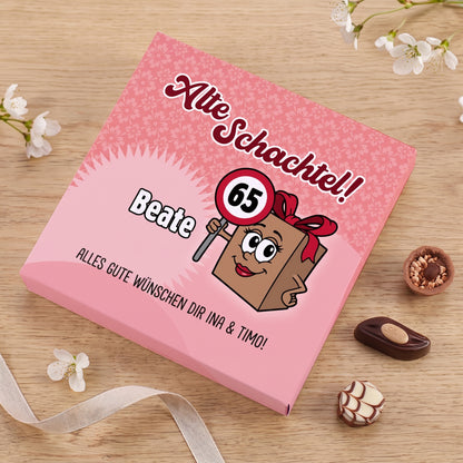 Personalisierte Lindt Pralinenschachtel Alte Schachtel mit Name Beate und Alter 65 auf Holztisch