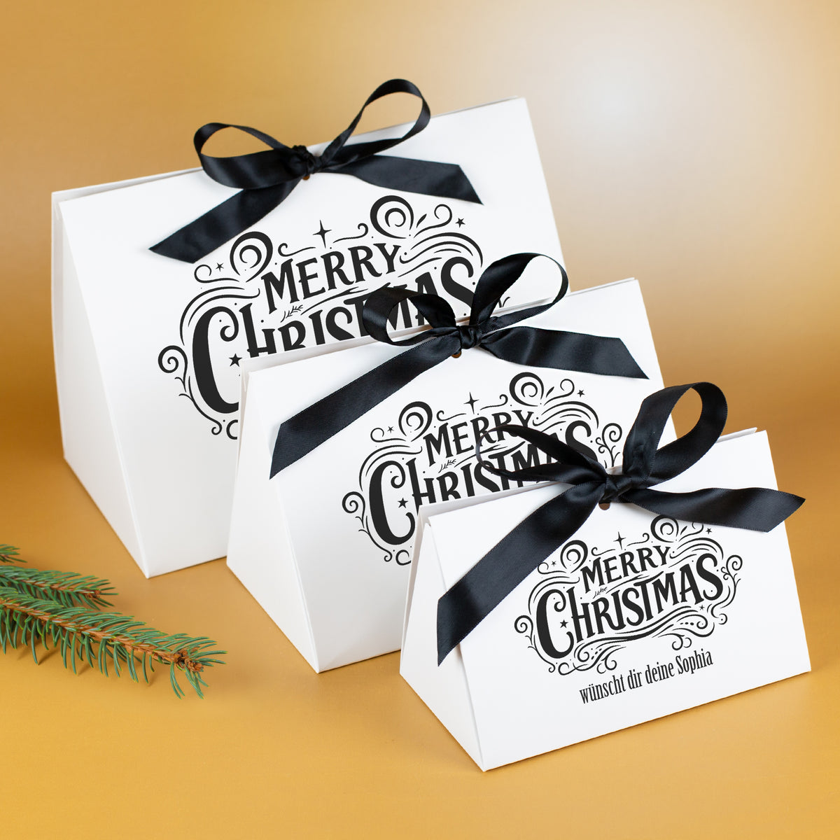 Drei Größen der personalisierten „Merry Christmas“-Geschenktasche mit schwarzen Satinschleifen im Größenvergleich