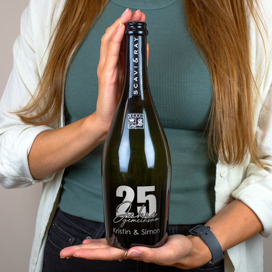 Person hält personalisierte Scavi & Ray Prosecco-Flasche zur Silberhochzeit mit Aufdruck 25 Jahre gemeinsam und Namen Kristin & Simon