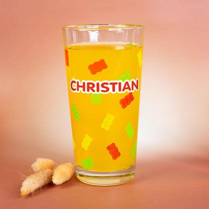 HARIBO Trinkglas mit personalisiertem Namen „Christian“, bunt bedruckte Gummibärchen rundum, dekoriert mit Trockenblumen auf warmem Hintergrund.