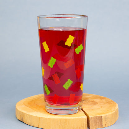 HARIBO Trinkglas mit buntem Gummibärchen Motiv, gefüllt mit gelbem Getränk auf warmem Hintergrund