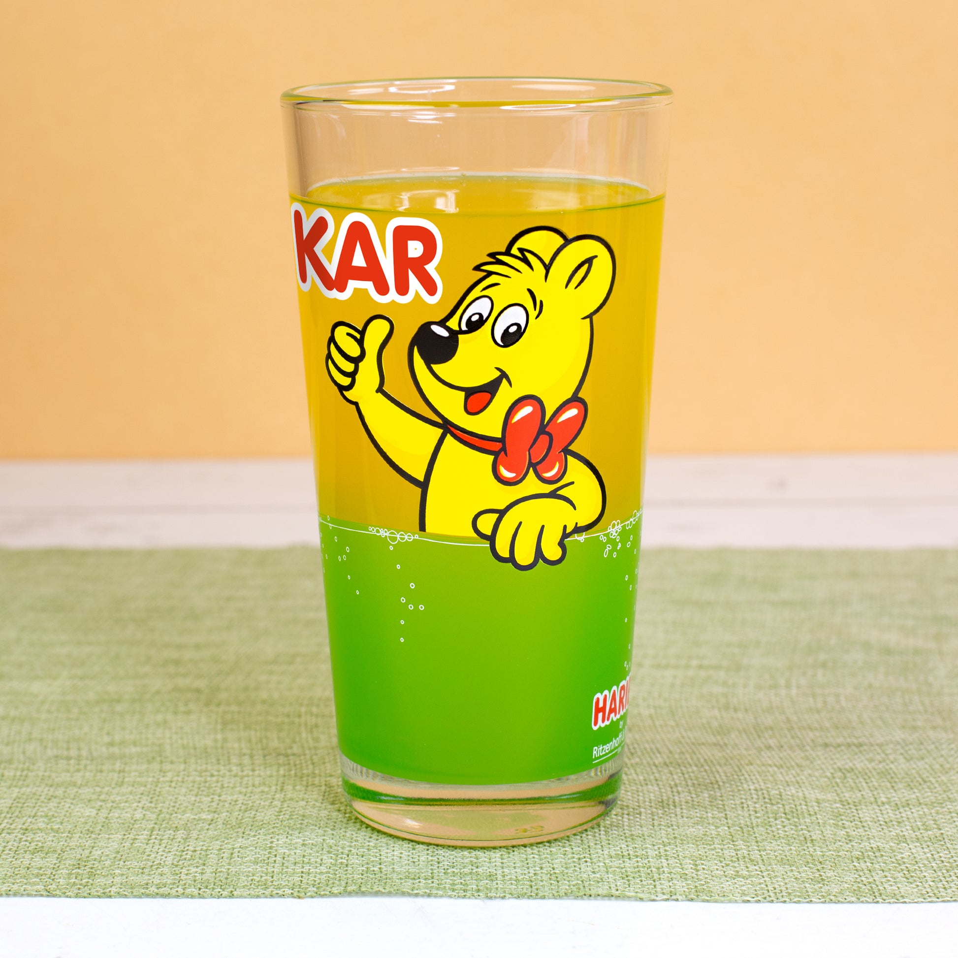 Seitenansicht des HARIBO Glases mit Goldbär und grünem Limonadenbereich, hochwertige Detailaufnahme.