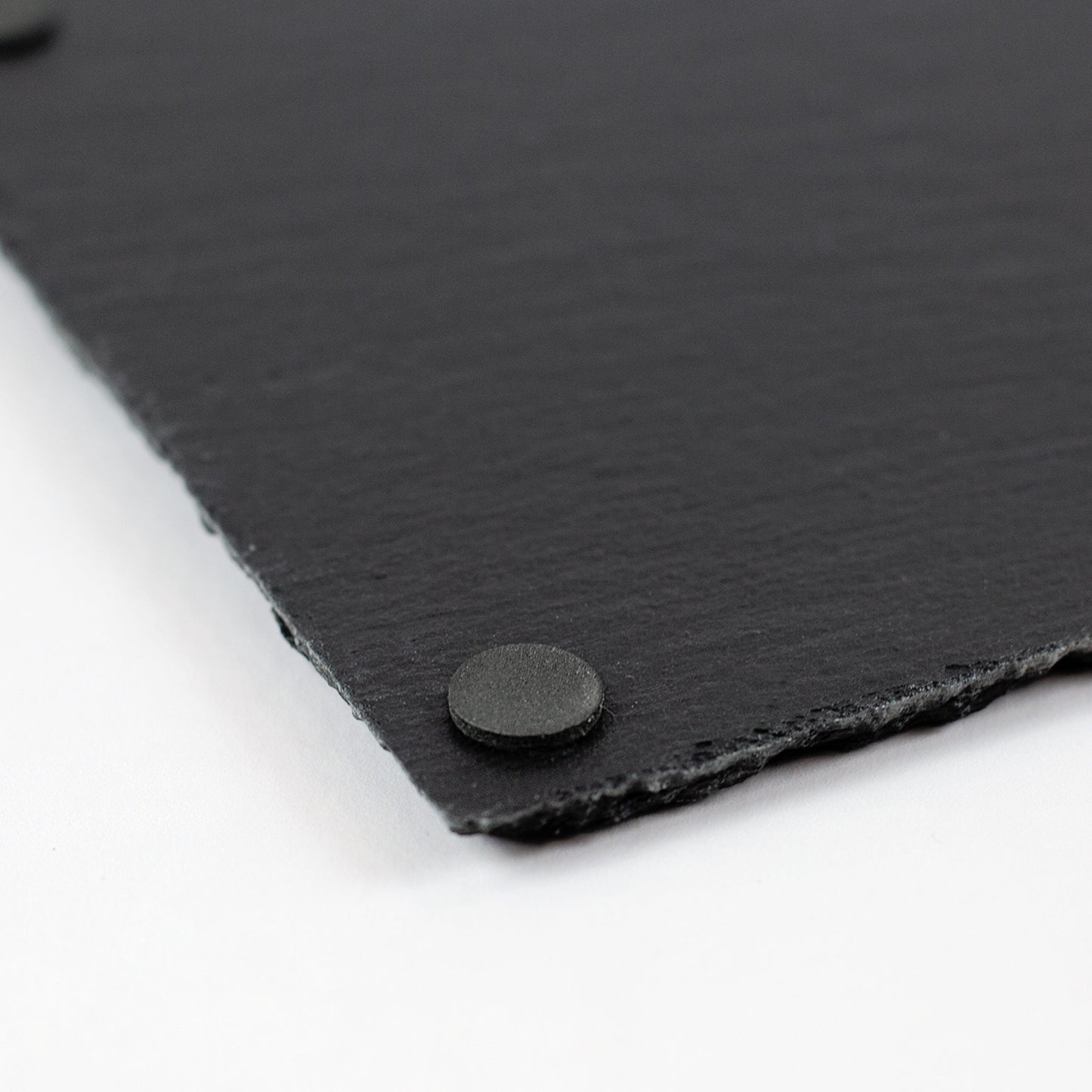 Detailaufnahme einer Schieferplatte mit rutschfesten Füßen auf der Unterseite