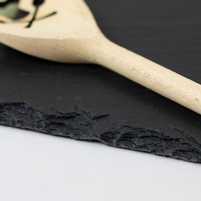 Nahaufnahme der natürlichen Bruchkante einer Schieferplatte mit Holzlöffel