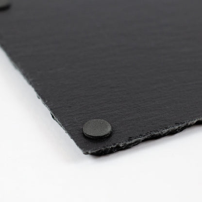 Detailaufnahme einer schwarzen Schieferplatte mit runder Anti-Rutsch-Noppe auf der Rückseite.