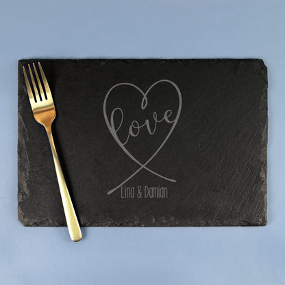 Schwarze Schieferplatte mit Herz-Motiv „Love“ und Namensgravur, dekoriert mit goldener Gabel