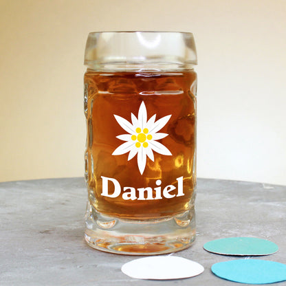 Schnapsglas im Bierkrug-Design mit Edelweiß-Motiv und Name Daniel – vor farbigen Konfettikreisen