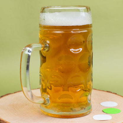 Personalisiertes Bierglas mit Henkel in der Seitenansicht auf einer Holzscheibe