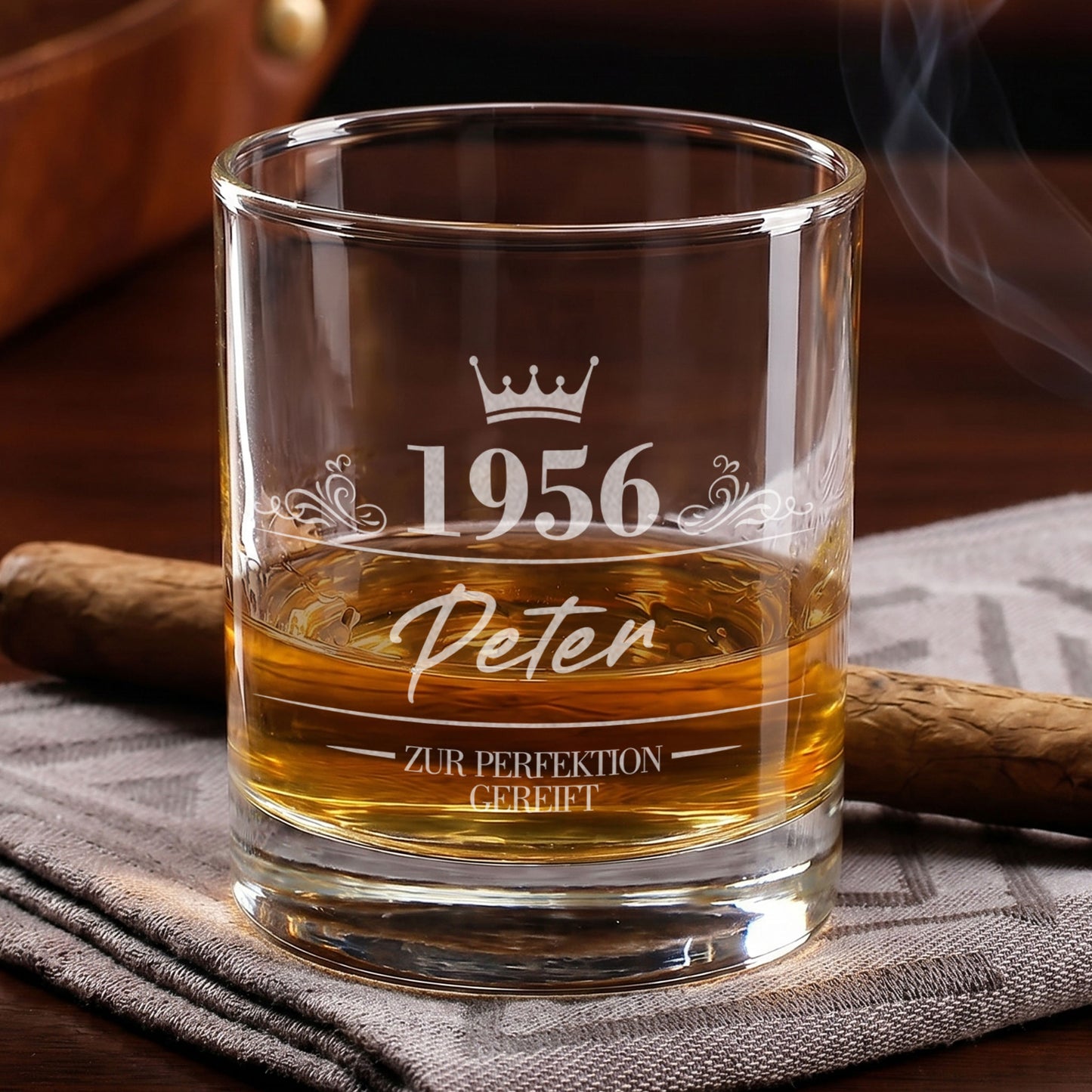 Personalisiertes Whiskyglas mit Gravur von 1956, Name Peter und Krone, gefüllt mit Whisky neben Zigarre