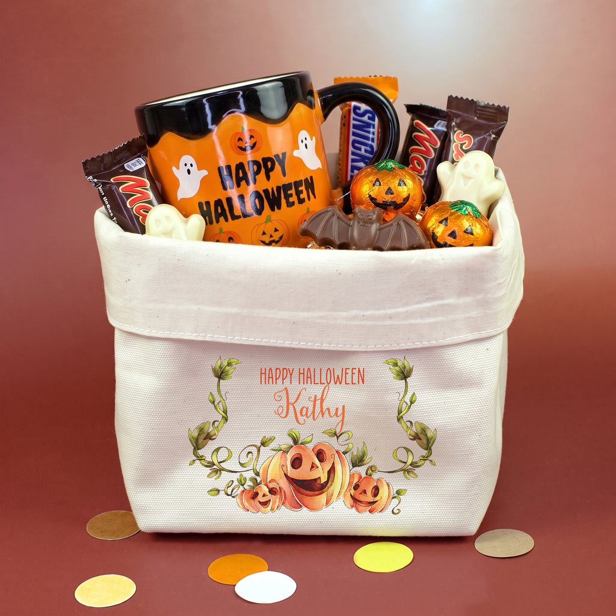 Personalisierter Halloween Boo Basket aus Stoff mit Kürbis Motiv und Name gefüllt mit Süßigkeiten und Becher