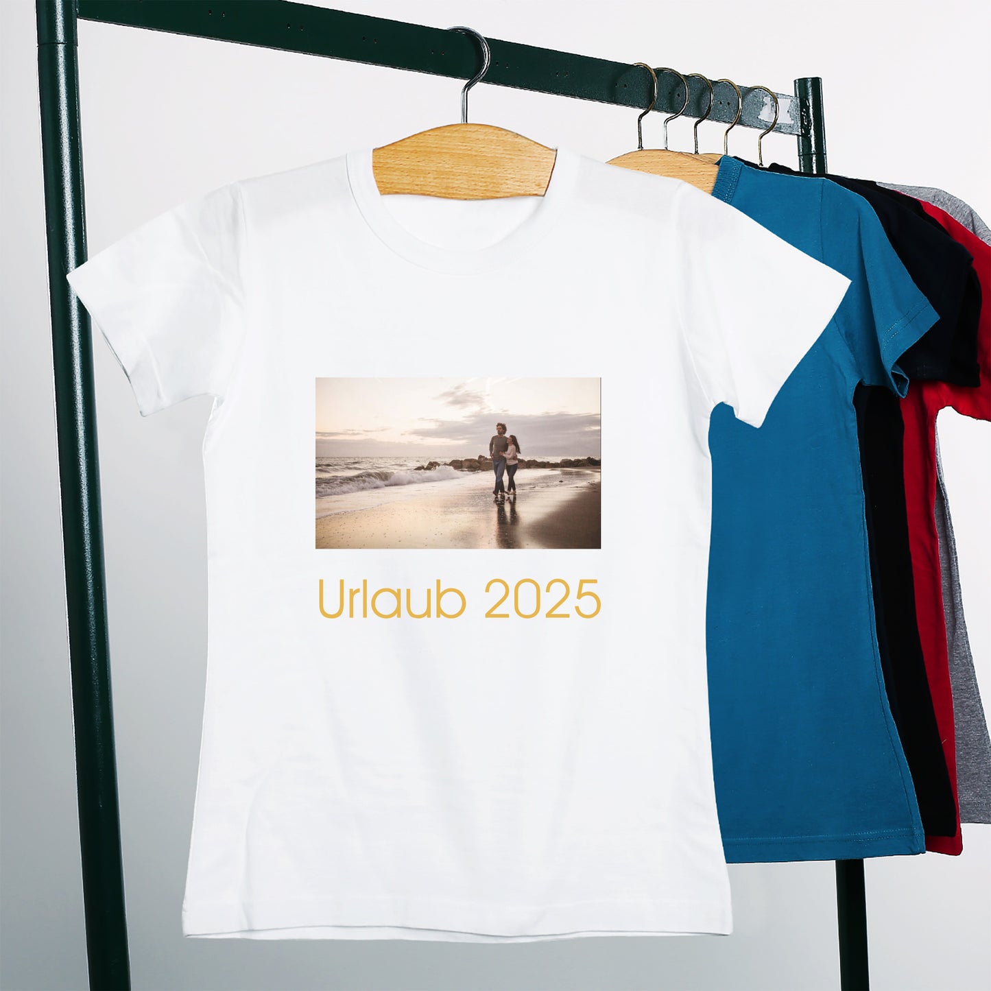 Weißes personalisiertes T-Shirt hängt mit anderen T-Shirts auf einem Kleiderbügel.