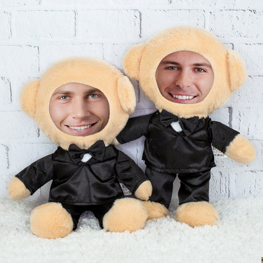 Zwei personalisierte Bräutigam-Teddys mit Foto-Gesichtern vor weißer Backsteinwand als lustiges Hochzeitsgeschenk
