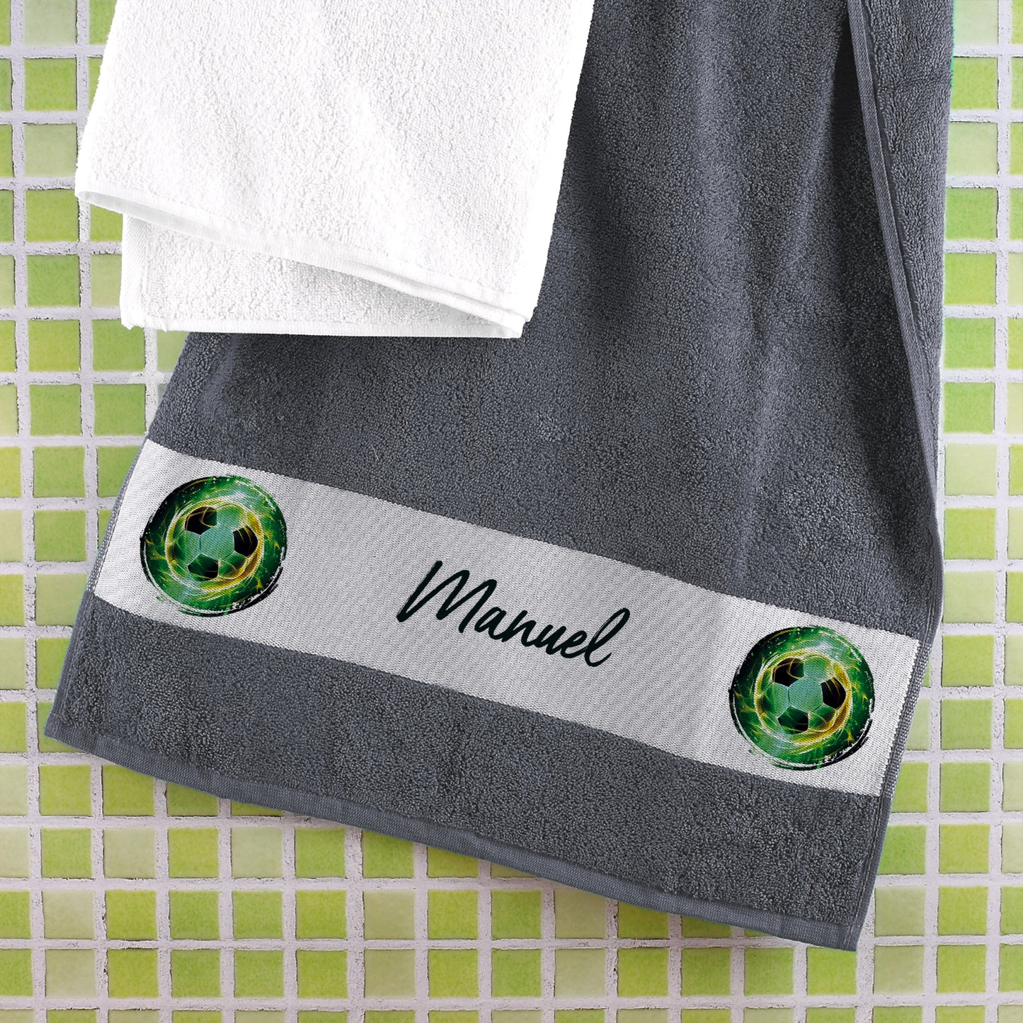 Fußball-Handtuch in Anthrazit mit Namensaufdruck „Manuel“ an Kachelwand