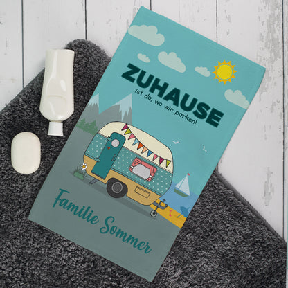 Personalisiertes Camping-Gästetuch mit Wohnwagen-Motiv und Wunschtext auf grauem Teppich