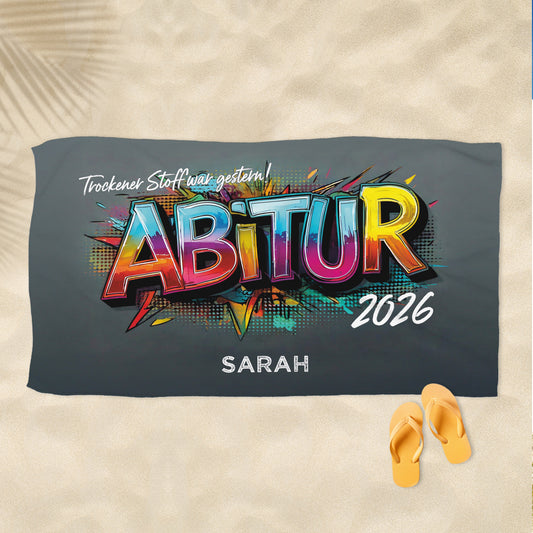 Personalisiertes Abitur-Handtuch mit buntem „ABITUR“-Graffiti-Schriftzug und Wunschtext, flach liegend dargestellt.