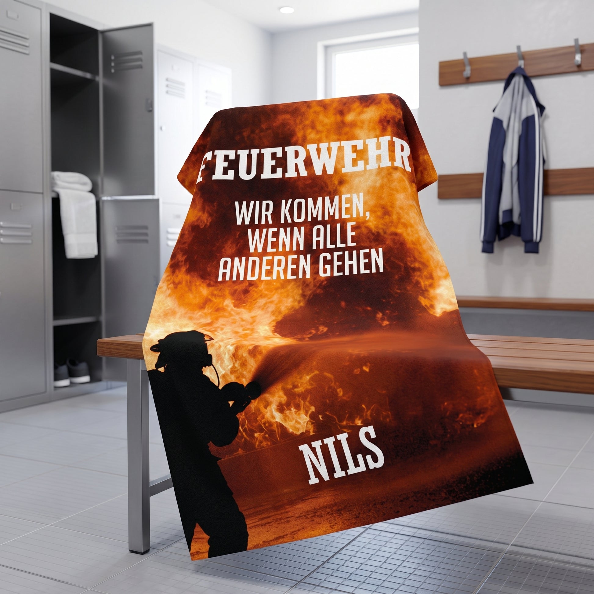 Feuerwehr Handtuch mit Name Nils über Bank in Umkleide, orangefarbenes Flammenmotiv mit Spruch