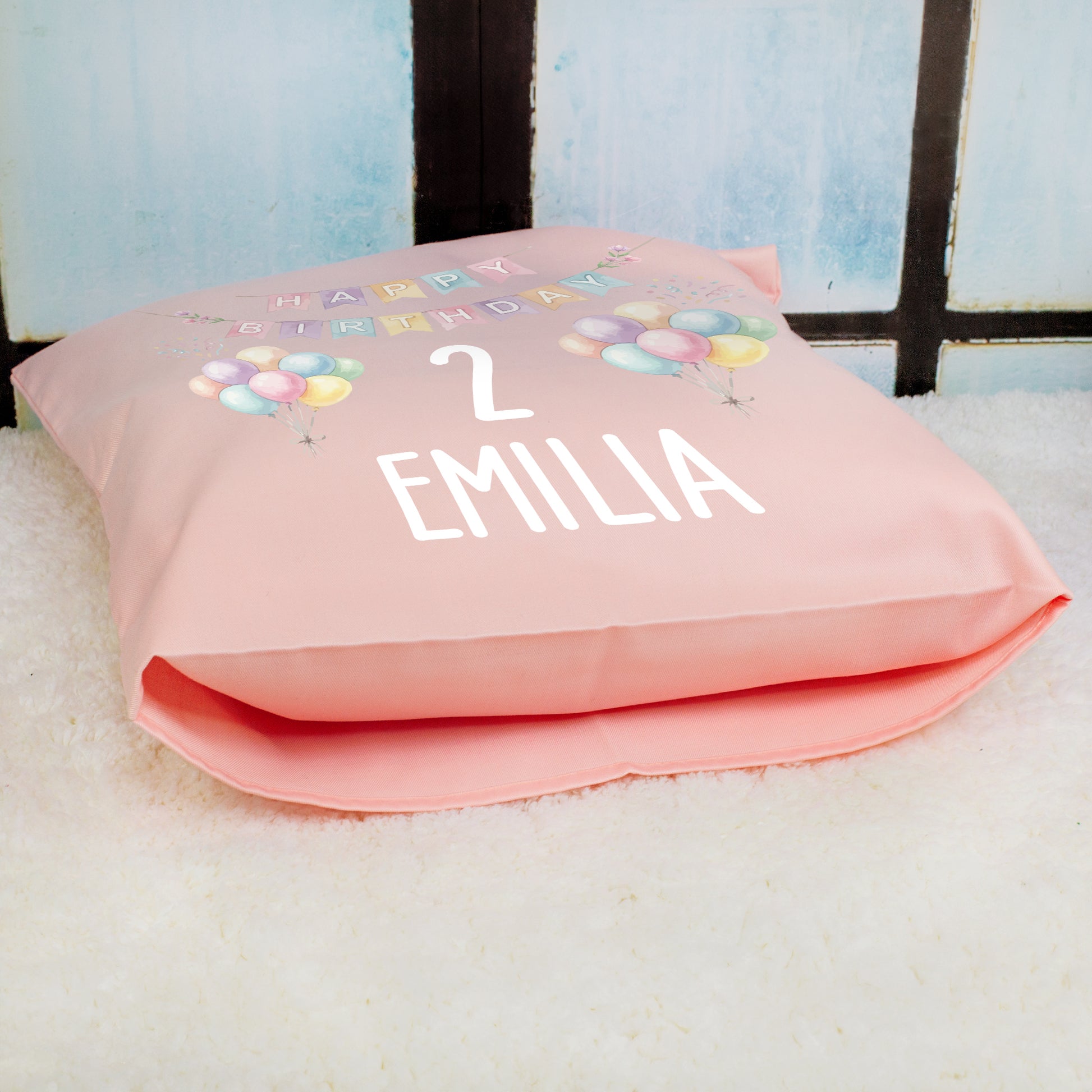Rosa personalisiertes Geburtstagskissen mit Ballons, Zahl 2 und Name Emilia liegend fotografiert