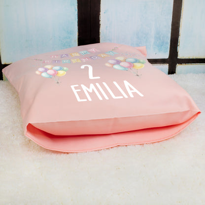 Rosa personalisiertes Geburtstagskissen mit Ballons, Zahl 2 und Name Emilia liegend fotografiert