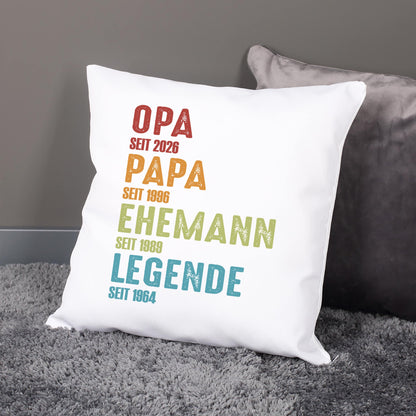 Weißes Kissen mit personalisiertem Text Opa Papa Ehemann Legende und individuellen Jahreszahlen auf grauem Sofa