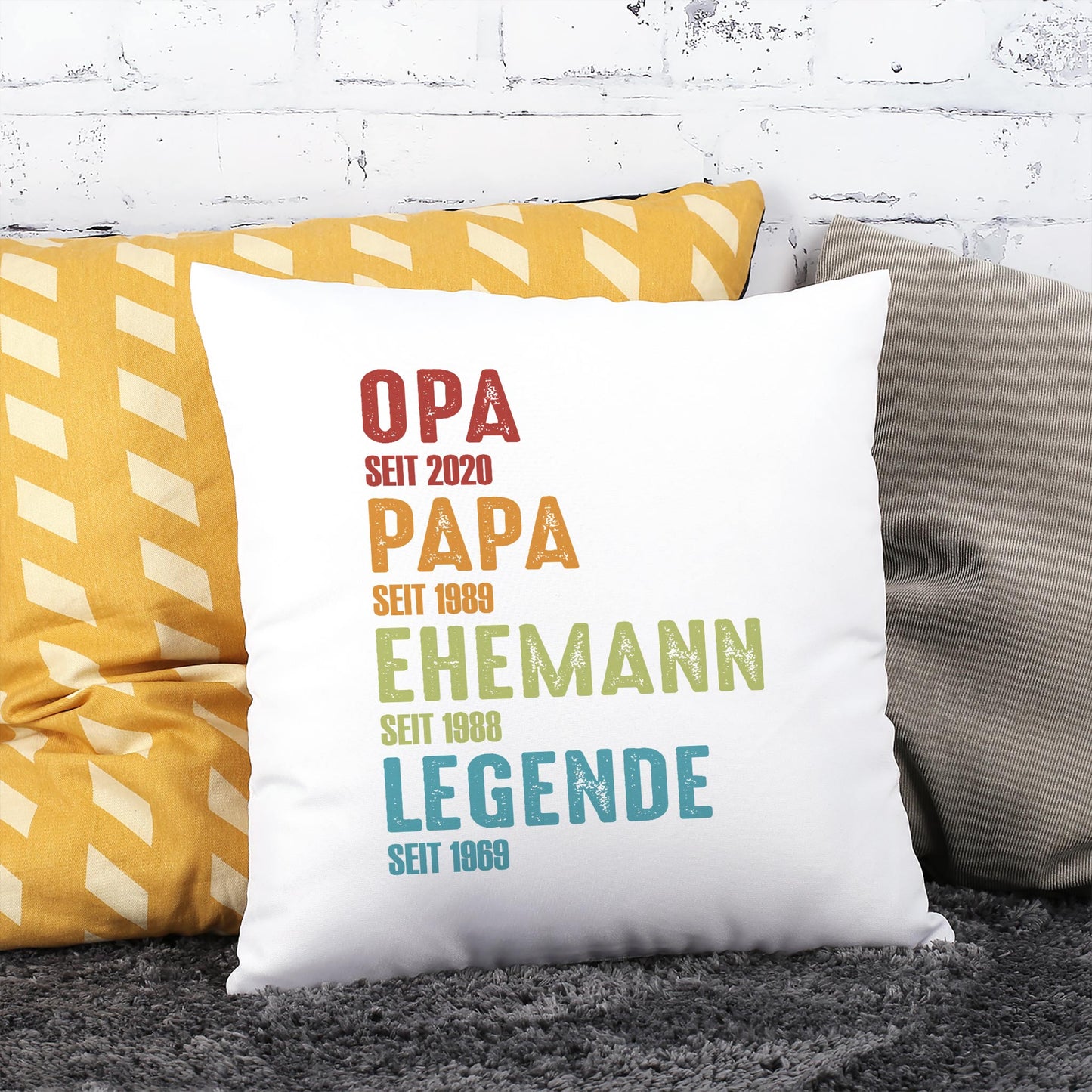 Personalisiertes Geschenk Kissen für Papa und Opa mit farbigem Schriftzug und Lebensmeilensteinen auf Sofa