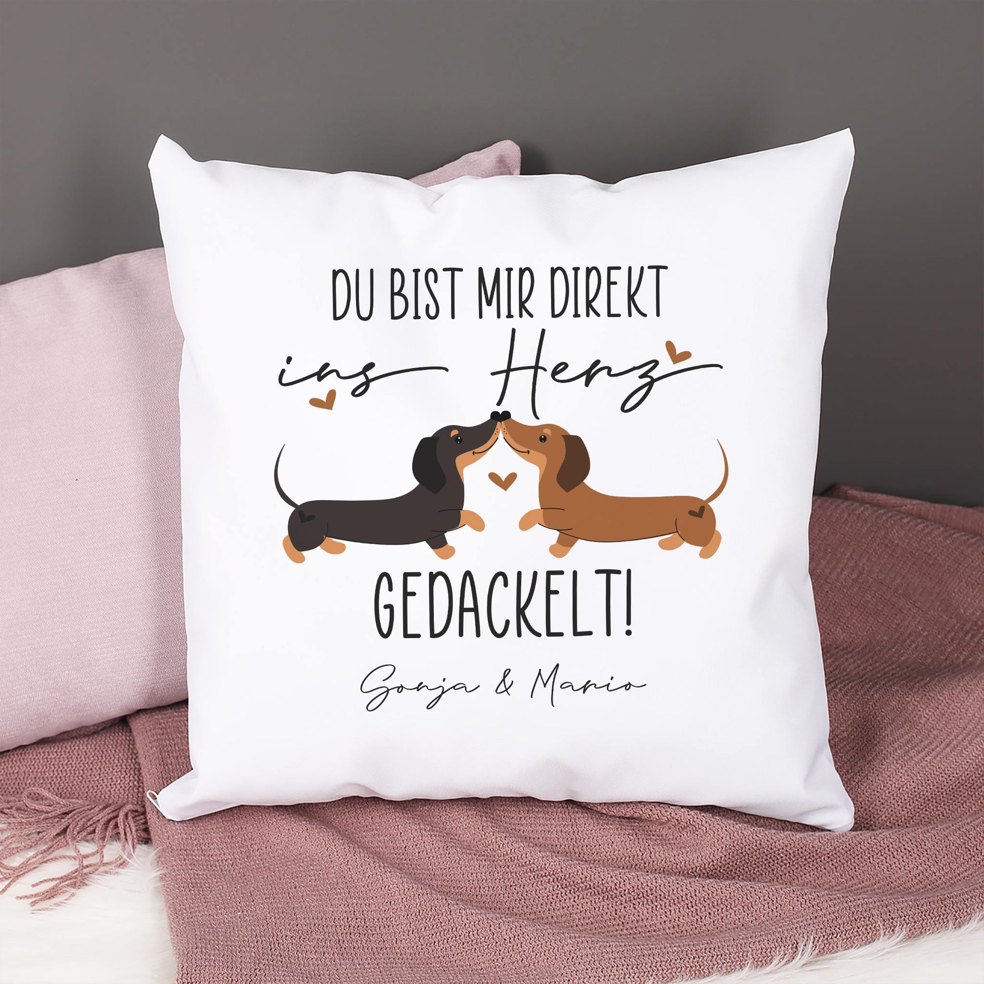 Dackel-Kissen personalisiert mit Wunschtext, Motiv mit zwei Hunden und Herzchen, Kissen auf Decke dekoriert