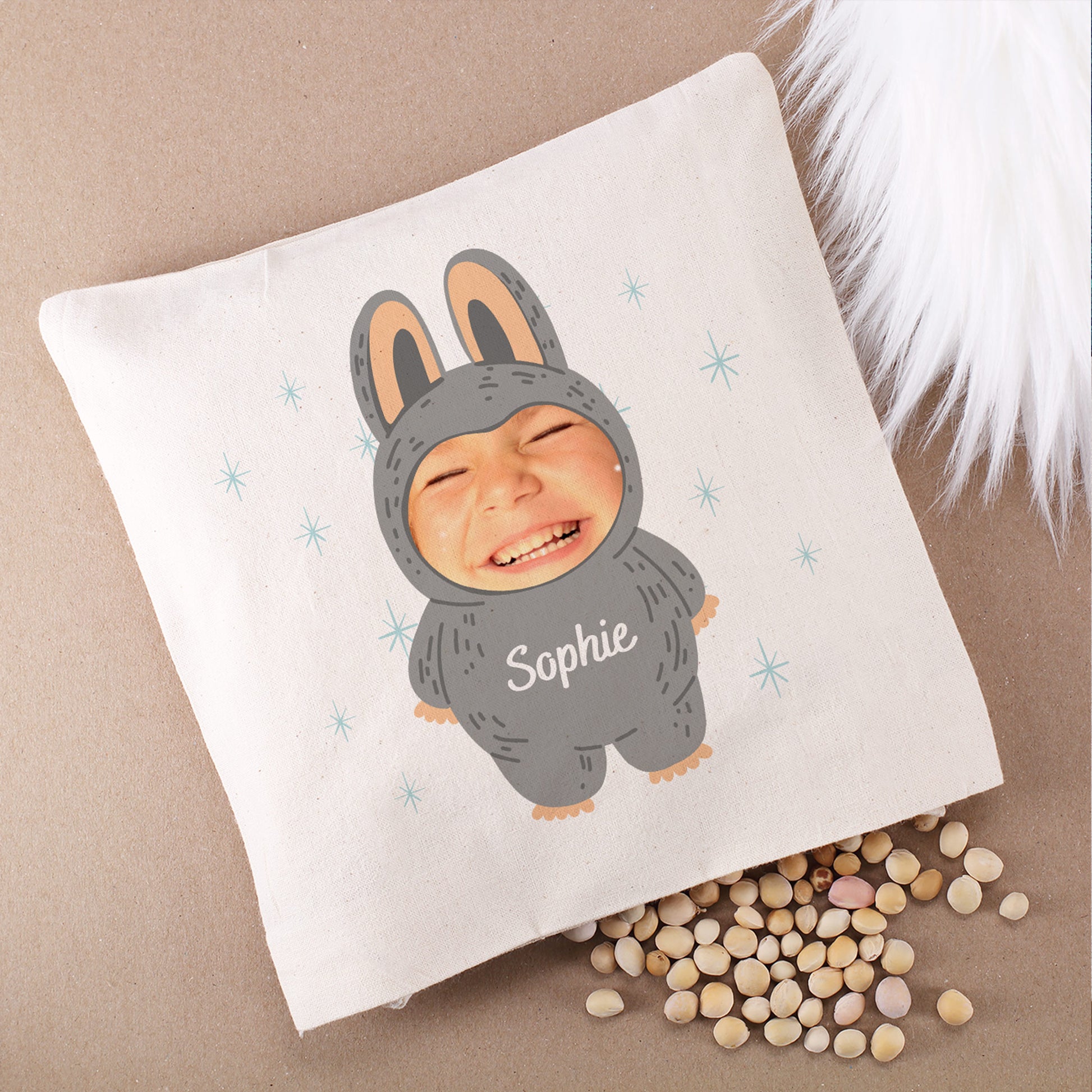 Kirschkernkissen mit Monster-Motiv in Grau, personalisiert mit Foto und Namen „Sophie“, auf hellem Hintergrund mit Kirschkernen