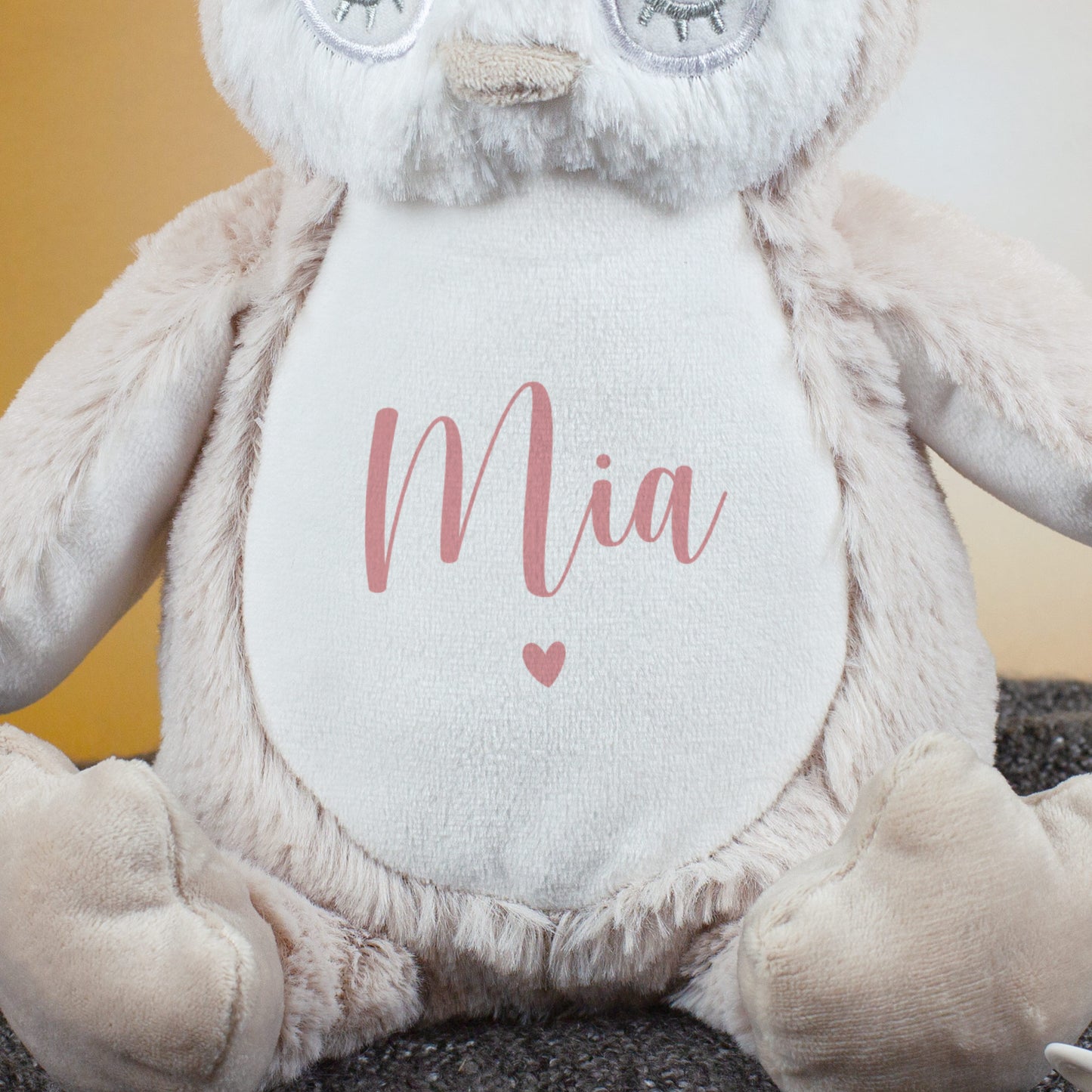 Nahaufnahme des Eulenbauchs mit rosa Personalisierung „Mia“ und kleinem Herzsymbol.