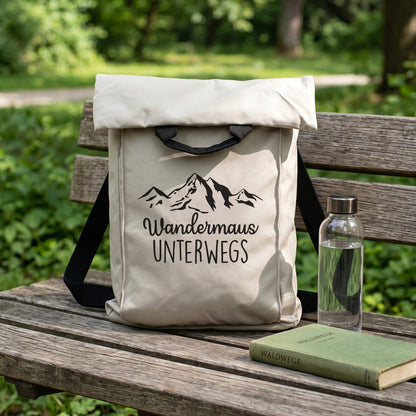 Beiger Wanderrucksack mit Bergmotiv und Wunschtext „Wandermaus unterwegs“ auf einer Parkbank