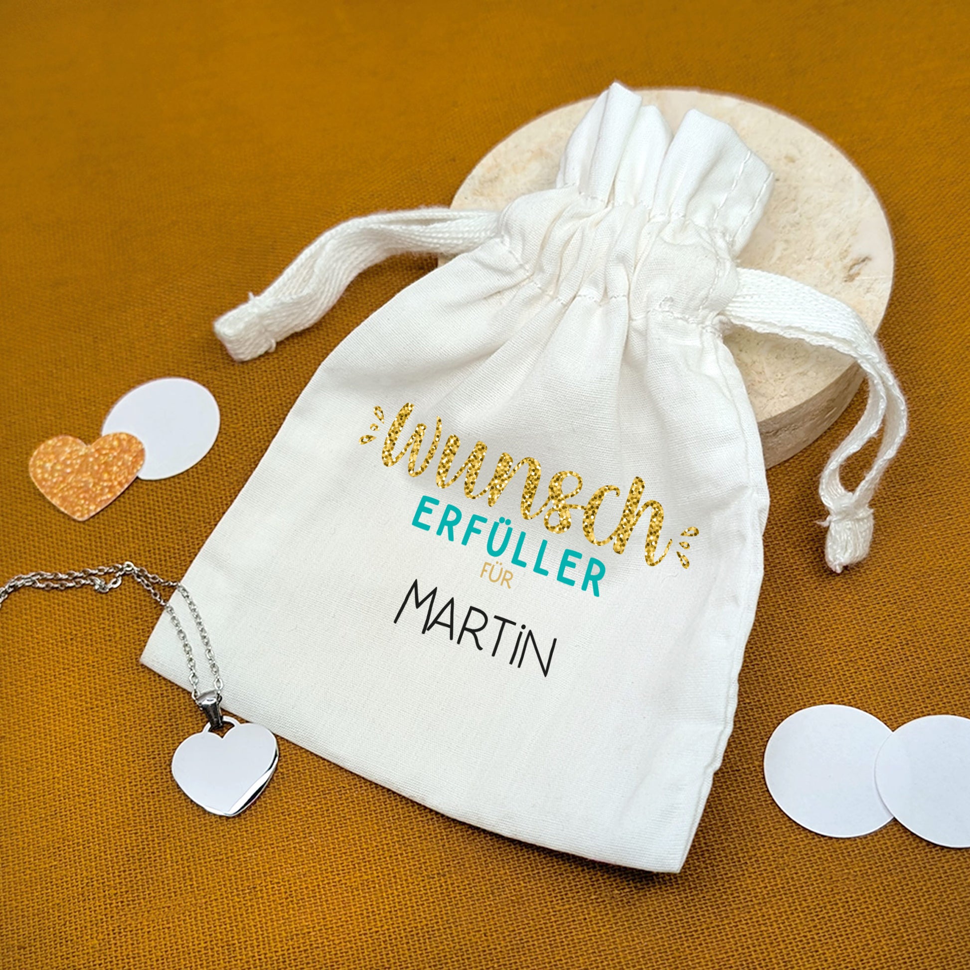 Stoffsäckchen mit Aufdruck Wunscherfüller für Martin, mit Herzanhänger – auf oranger Unterlage