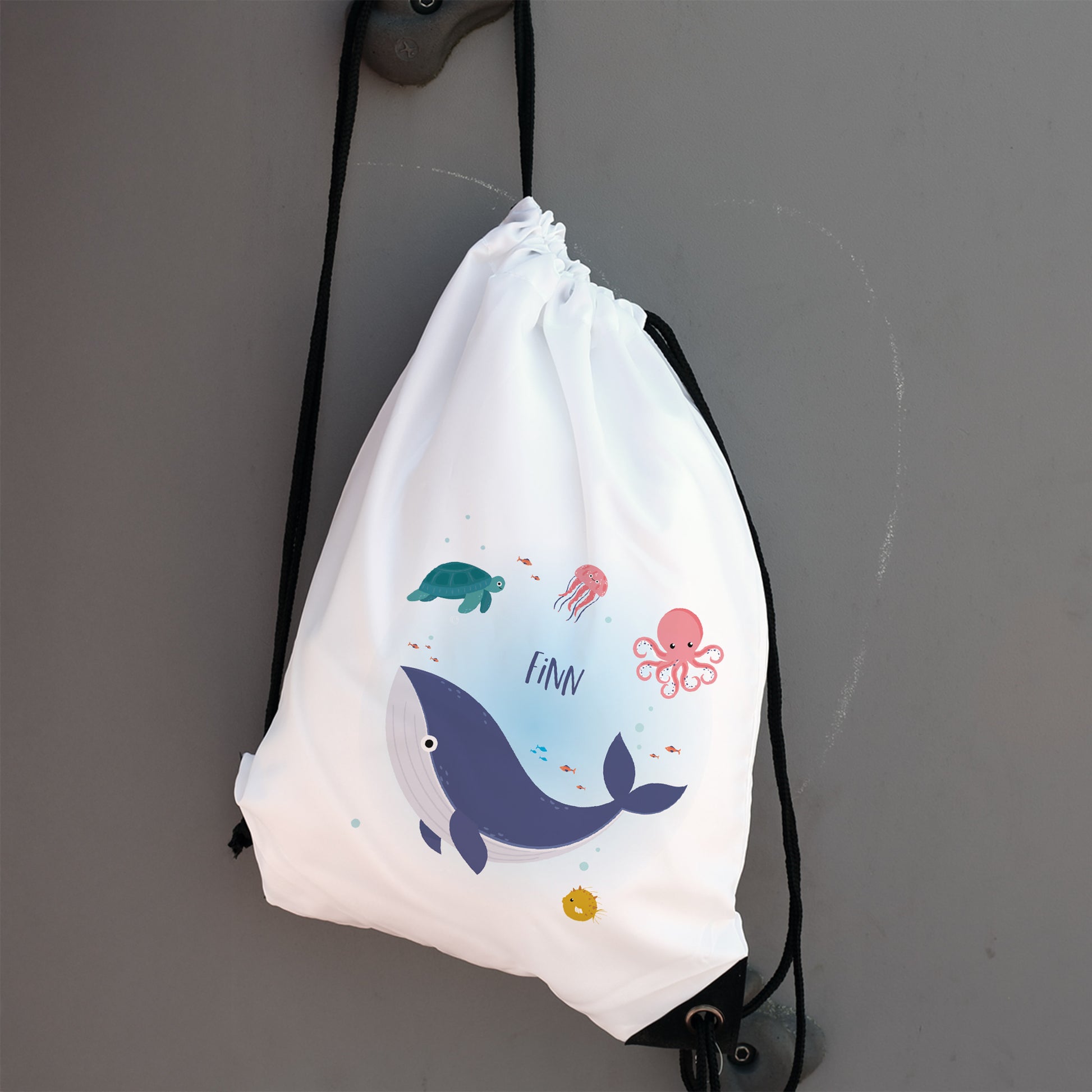 Weißer Turnbeutel mit Meeresfreunde-Motiv und Name Finn an Haken