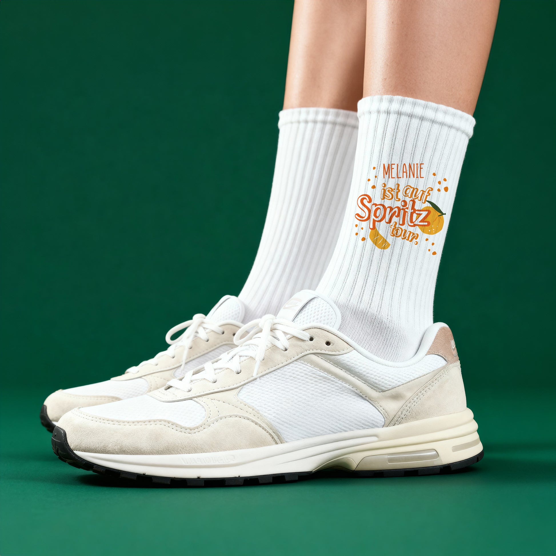 Weiße Tennissocken mit Spritz-Tour-Motiv und personalisiertem Namen, getragen mit weißen Sneakern.